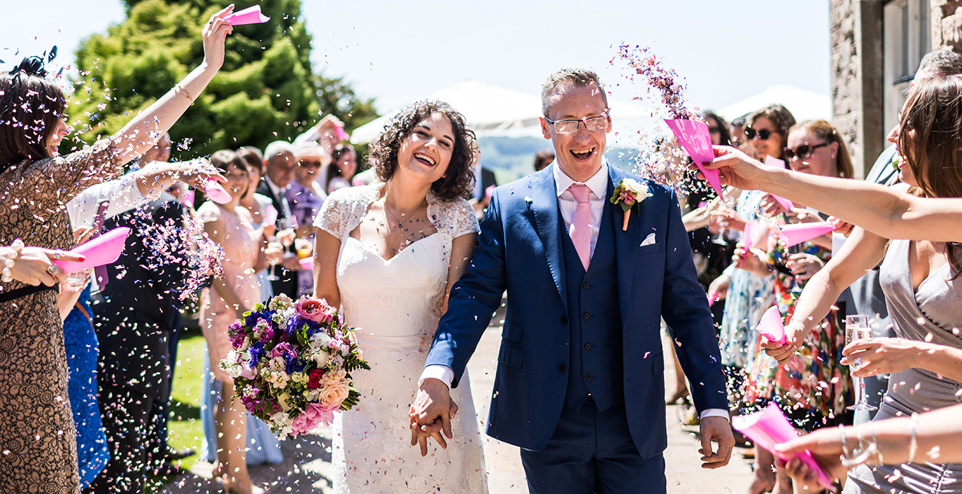 Wedding couple walking with confetti